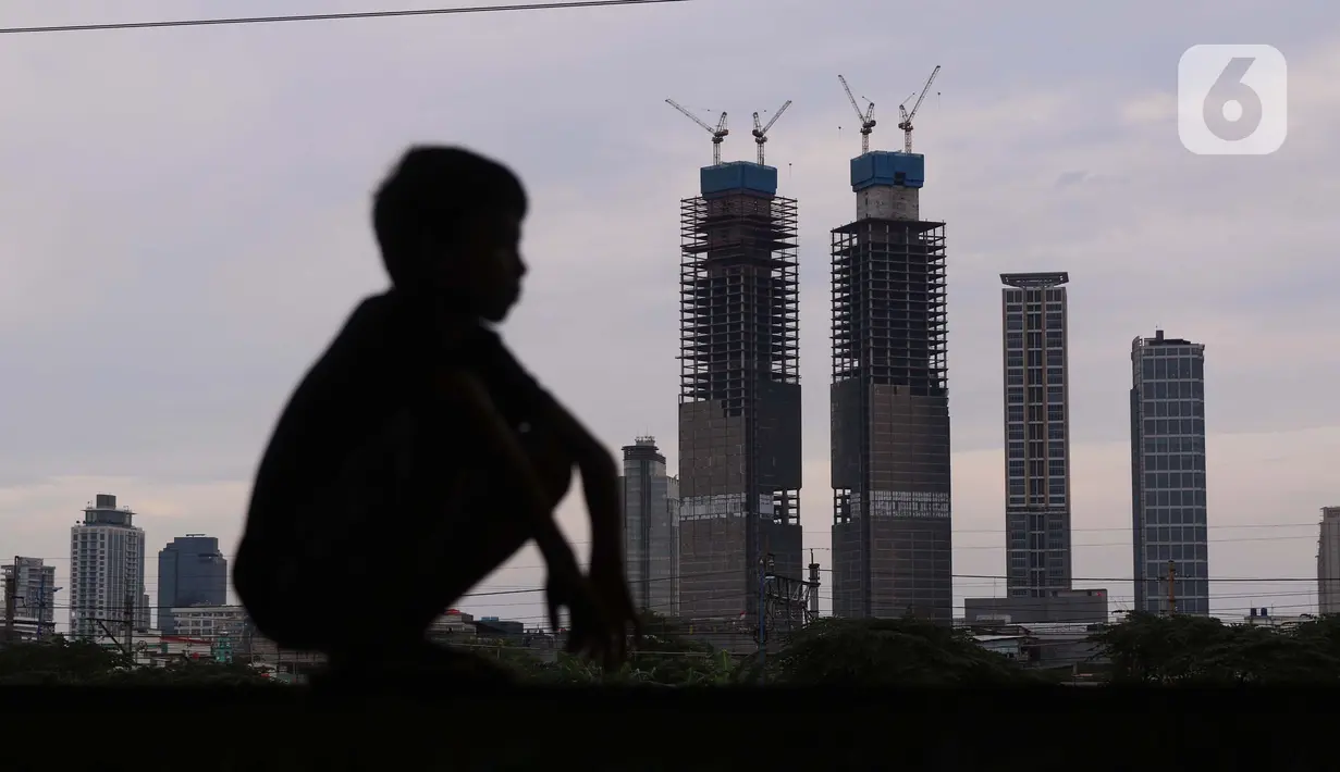 Seorang melihat gedung bertingkat di Jakarta, Sabtu (19/3/2022). Bank Indonesia (BI) memperkirakan pertumbuhan ekonomi Indonesia akan meningkat lebih tinggi, pada kisaran 4,7 persen hingga 5,5 persen, dari pertumbuhan 3,69 persen pada 2021. (Liputan6.com/Angga Yuniar)