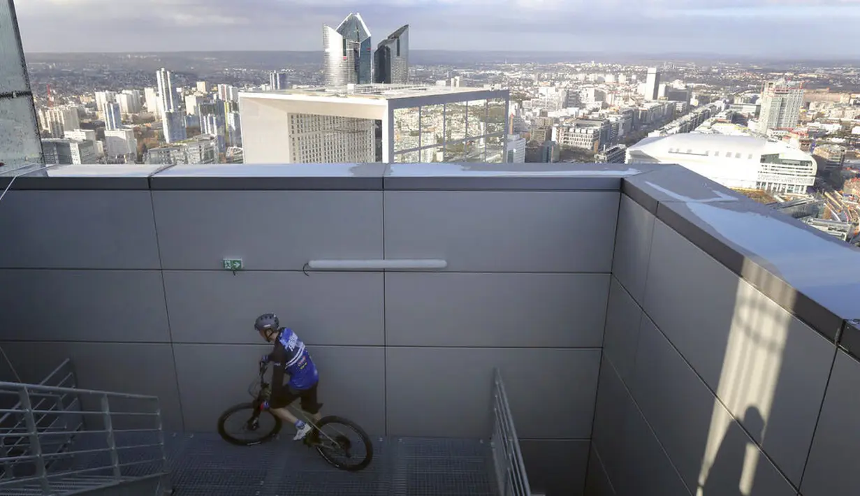 Pembalap sepeda asal Prancis, Aurelien Fontenoy, saat mendaki 768 anak tangga dari 33 lantai gedung Trinity Tower di distrik La Defense, Paris, (17/1/2021). (AP/Christophe Ena)
