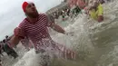 Warga Belgia berbondong-bondong menyerbu perairan Laut Utara untuk merayakan akhir pekan perrtama 2019 di Ostend, Sabtu (5/1). Tak sekadar bermain air, sebagian warga juga beraksi dengan kostum berwarna-warni. (AP/Francisco Seco)