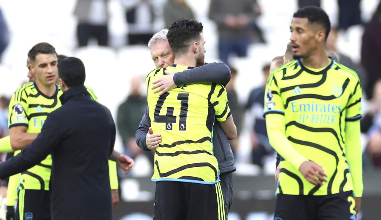 Pemain Arsenal, Declan Rice, berpelukan dengan pelatih  West Ham United, David Moyes, dalam duel pekan ke-24 Premier League 2023/2024 di Stadion London, Minggu (11/2/2024). Hasil ini menjaga posisi Arsenal di peringkat tiga klasemen Liga Inggris dengan 52 poin. (AP Photo/Ian Walton)