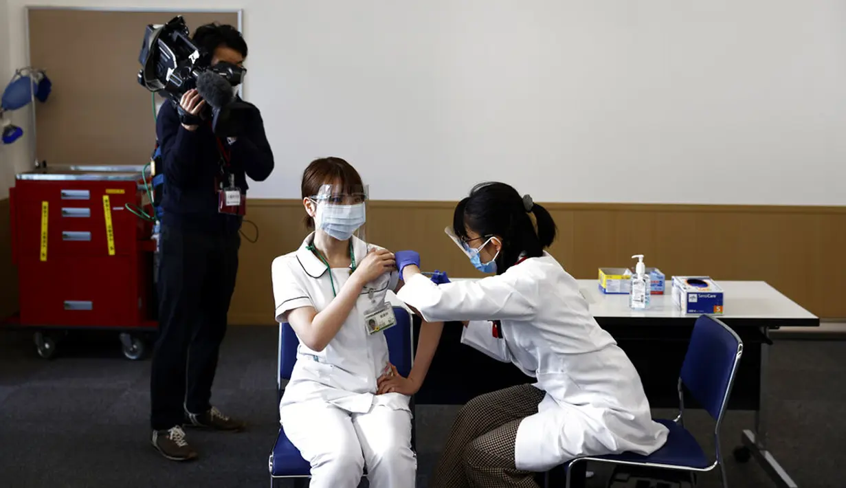 Seorang pekerja medis menerima dosis vaksin virus corona COVID-19 di Tokyo Medical Center, Tokyo, Jepang, Rabu (17/2/2021). Jepang memulai kampanye vaksinasi COVID-19 dengan suntikan COVID-19 pertama diberikan kepada petugas kesehatan. (Behrouz Mehri/Pool Photo via AP)