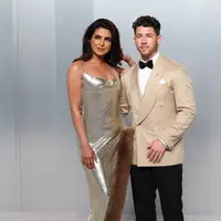 Pasangan power couple, Priyanka Chopra dan Nick Jonas, kembali membuktikan status mereka sebagai fashion icon. Priyanka mengenakan gaun metalik rancangan Stella McCartney dengan aksen fur yang dramatis, sementara Nick tampil sleek dalam tuxedo krem yang clean. Keduanya menghadirkan harmoni antara bold femininity dan refined masculinity.