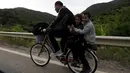 Seorang imigran suriah menaniki sepeda bersama dua orang anaknya di dekat perbatasan Yunani di Makedonia, Rabu (17/6/2015). Mereka mencari perlindungan dengan menempuh ribuan kilometer. (REUTERS/Ognen Teofilovski)