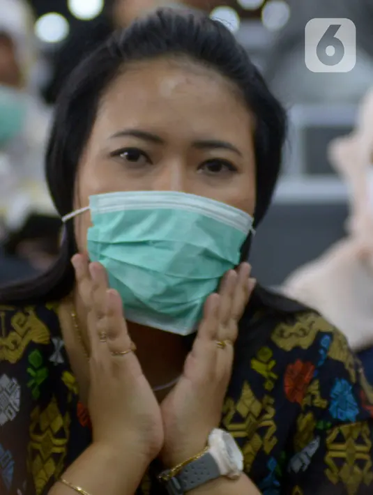 Calon penumpang mengenakan masker saat menunggu jadwal keberangkatan kereta di Stasiun Gambir, Jakarta Pusat, Jumat (31/01). Dalam rangka pencegahan Virus Corona, PT Kereta Api Indonesia (persero) melakukan sosialisasi kepada penumpang dengan membagi-bagikan masker. (merdeka.com/Imam Buhori)