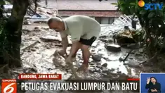 Petugas gabungan dari polisi dan TNI dibantu warga terus berupaya mengevakuasi kendaraan pribadi yang rusak akibat terjangan banjir.