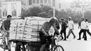 Seorang pria mengendarai gerobak yang penuh dengan barang dagangan di kota Beijing, China pada 23 Juli 1973.  (AFP Photo)