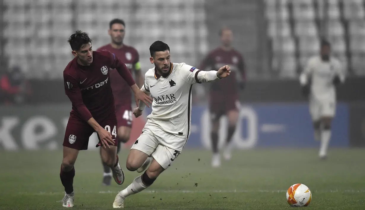 Gelandang  CFR Cluj, Catalin Mihai Itu (kiri) berusaha merebut bola dari bek AS Roma, Leonardo Spinazzola selama pertandingan grup A Liga Europa di Cluj-Napoca, Rumania (26/11/2020). AS Roma menang 2-0 atas CFR Cluj. (AFP/Alex Nicodim)