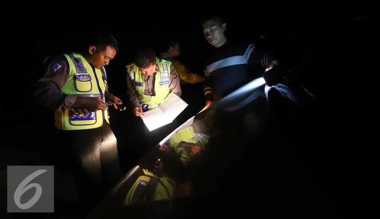 Petugas kepolisian mendata kendaraan yang terlibat kecelakaan beruntun di Jalan Jenderal Ahmad Yani, Tasikmalaya, Jawa Barat, Minggu (3/7) dini hari. Tidak ada korban dalam kecelakaan tersebut. (Liputan6.com/Immanuel Antonius)