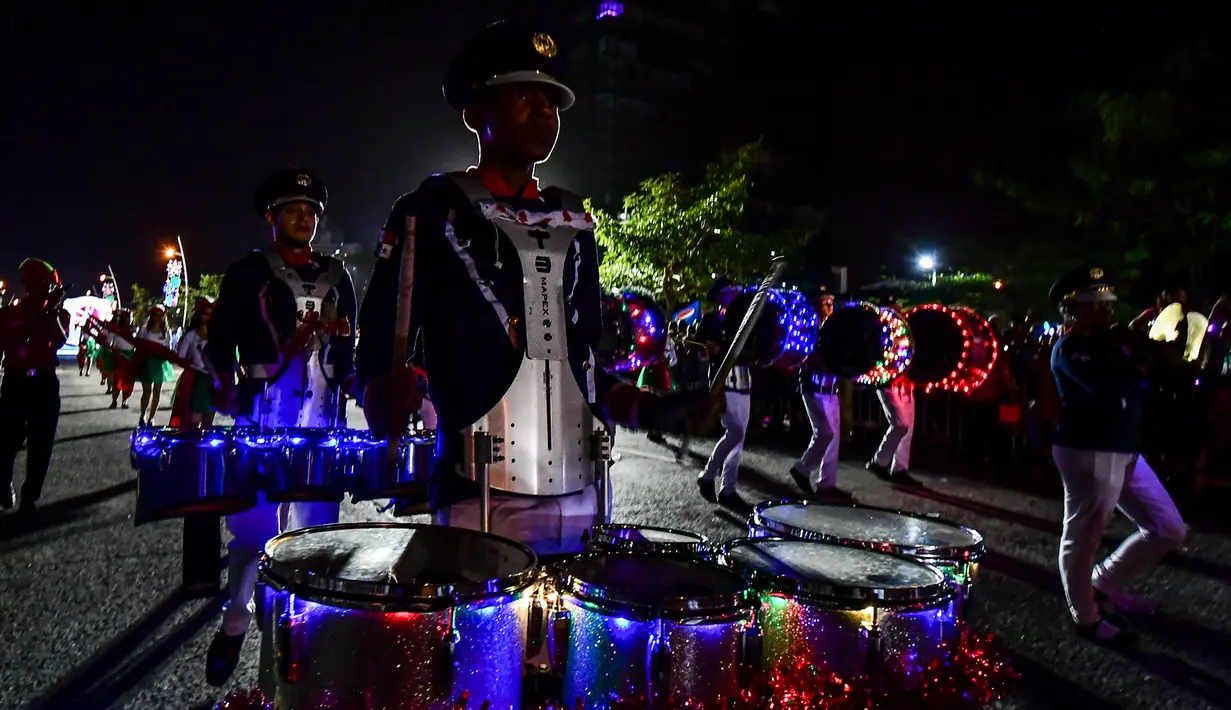 Seorang pria memainkan drum selama parade Natal di Panama City (16/12). Warga Panama tengah mempersiapkan diri menyambut datangnya Natal 2018 yang jatuh pada tanggal 25 Desember. (AFP Photo/Luis Acosta)
