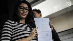 Artis peran Tyas Mirasih menunjukkan surat laporan pencemaran nama baik usai melapor ke Polda Metro Jaya, Jakarta, Rabu (21/3). Sebelumnya, Tyas dituduh menculik anak perempuan berusia lima tahun berinisial ACB. (Liputan6.com/Faizal Fanani)