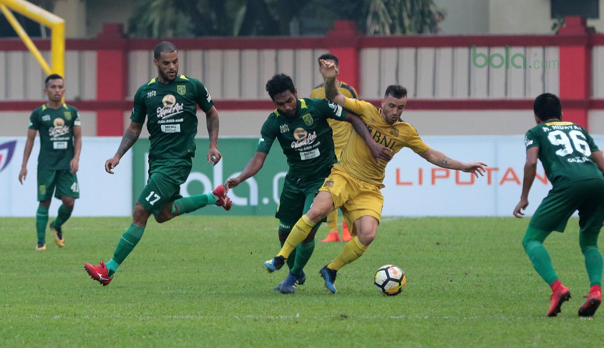 Paulo Sergio mencoba melewati adangan para pemain Persebaya Surabaya pada laga Gojek Liga 1 bersama Bukalapak di Stadion PTIK, Jakarta, Rabu (11/7/2018). Bhayangkara FC bermain imbang 3-3. (Bola.com/Nick Hanoatubun)