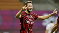 Pemain AC Milan, Hakan Calhanoglu, melakukan selebrasi usai membobol gawang Bologna pada laga Serie A di Stadion San Siro, Sabtu (18/7/2020). AC Milan menang dengan 5-1 atas Bologna. (AP/Luca Bruno)