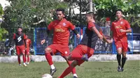 Bek Arema FC, Taufik Hidayat menghalangi pemain akademi Arema dalam sesi latihan di lapangan Balearjosari, Kota Malang. (Iawan Setiawan/Bola.com)