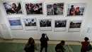 Sejumlah pengunjung mengambil foto saat pameran karya fotografer Agence France-Presse (AFP) mengenai krisis migrasi di Eropa di pusat seni Bozar di Brussels (3/5). Pameran ini berjudul "Puting a Face on the Invisibles. (AFP Photo/John Thys)