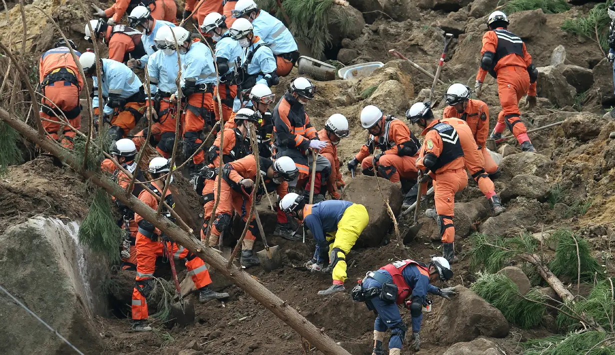 Petugas penyelamat dan polisi berusaha mencari korban usai terjadi longsor yang menghantam rumah hunian di Nakatsu, Prefektur Oita, Jepang (11/4). Sedikitnya enam orang hilang setelah tertimbun longsor. (AFP Photo/Jiji Press/Japan Out)