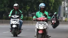 Pengemudi ojek online mengoperasikan telepon seluler sambil mengendarai sepeda motor di Jalan Gatot Subroto, Jakarta, Kamis (8/3). Polisi menilai tindakan itu membahayakan karena pengemudi menjadi tidak fokus di jalan raya. (Liputan6.com/Arya Manggala)