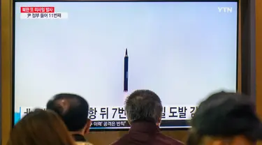 Orang-orang duduk di dekat layar televisi yang menayangkan siaran berita dengan rekaman file uji coba rudal Korea Utara, di sebuah stasiun kereta api di Seoul, Korea Selatan, Minggu (9/10/2022). Sejumlah pejabat Jepang mengatakan Korea Utara menembakkan dua rudal balistik pada Minggu pagi. (Photo by ANTHONY WALLACE / AFP)