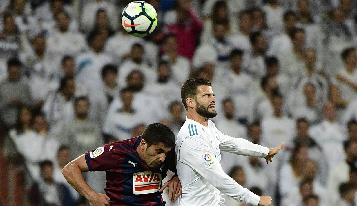 Duel pemain Real Madrid, Nacho Fernandez (kanan) dan pemain Eibar, Jose Angel pada lanjutan La Liga Santander di Santiago Bernabeu stadium, Madrid, (22/10/2017). Madrid menang 3-0. (AFP/Pierre-Philippe Marcou)