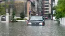 Sebuah taksi terjebak banjir di Saga, Jepang, Rabu (28/8/2019). Sejumlah lokasi rawan banjir dan tanah longsor di Jepang saat ini mencakup Saga, Fukuoka, dan Nagasaki di utara Kyushu. (Kyodo News via AP)