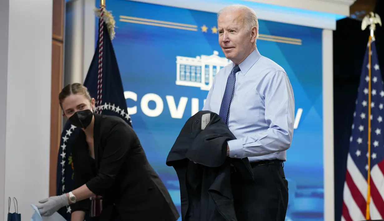 Presiden Joe Biden melepas jaket sebelum disuntik dosis keempat vaksin COVID-19 Pfizer/BioNTech keduanya di South Court Auditorium di Gedung Putih, Rabu (30/3/2022). AS pada Selasa mengizinkan orang berusia di atas 50 tahun dan kondisi rentan bisa menerima booster kedua. (AP Photo/Patrick Semansky)