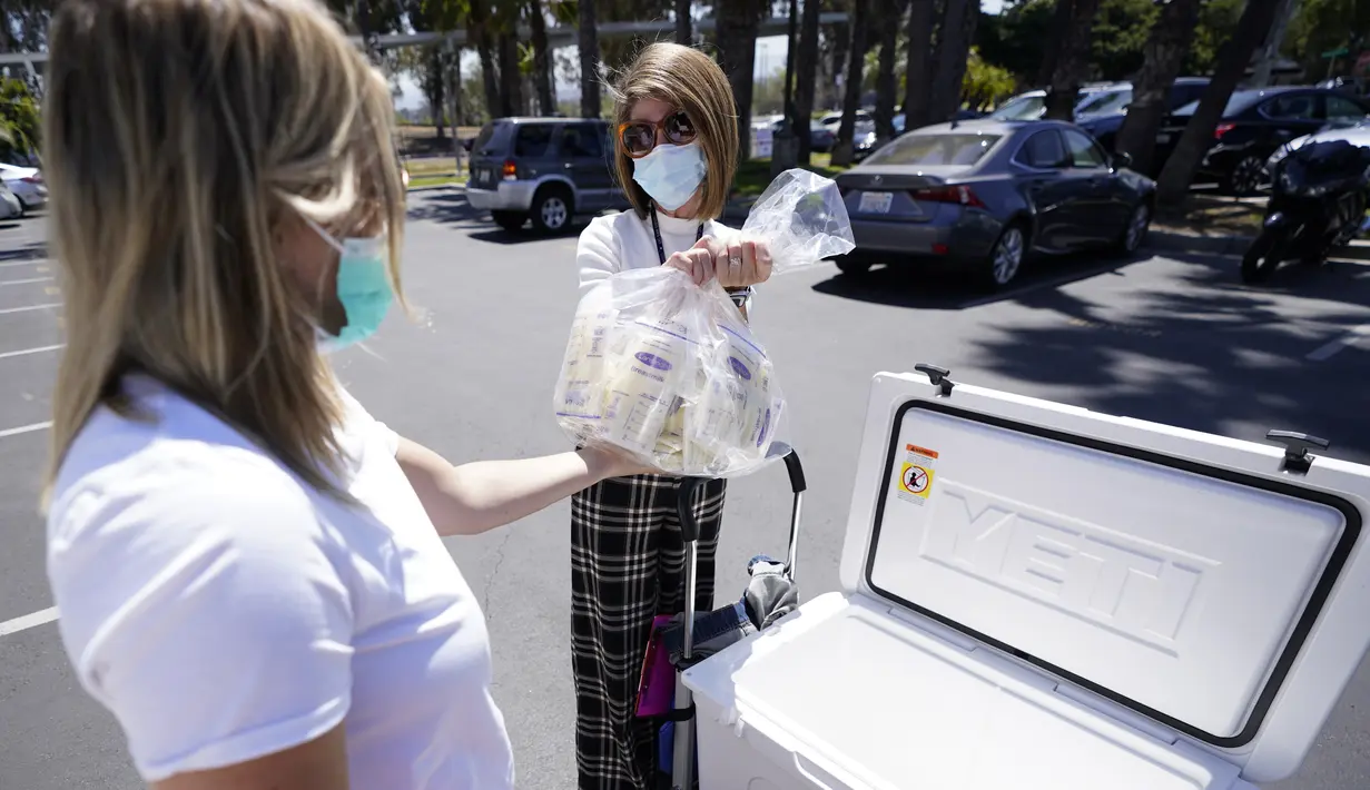 <p>Seorang perempuan (kiri) mendonorkan ASI kepada karyawan University of California Health Milk Bank, di San Diego, Jumat (13/5/2022). Kelangkaan susu formula bayi di Amerika Serikat telah memicu gelombang minat di kalangan ibu yang ingin menyumbangkan ASI untuk membantu menjembatani kesenjangan pasokan serta mereka yang ingin bayi mereka tetap makan. (AP Photo/Gregory Bull)</p>