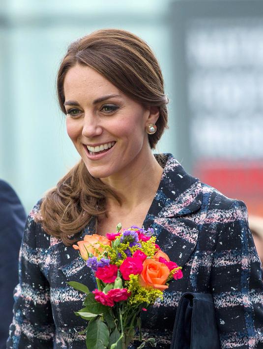 Kate Middleton terlihat cantik membawa bunga saat mengunjungi Meseum Nasional Sepak Bola di Manchester, Inggris (14/10). (Reuters/Charlotte Graham)