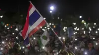 Pengunjuk rasa pro-demokrasi mengibarkan bendera selama protes di Sanam Luang di Bangkok, Thailand (19/9/2020). Para pengunjuk rasa mengulangi tuntutan agar monarki Thailand tetap berada di bawah konstitusi dalam demonstrasi terbesar sejak kudeta militer pada 2014. (AP Photo/Wason Wanichakorn)