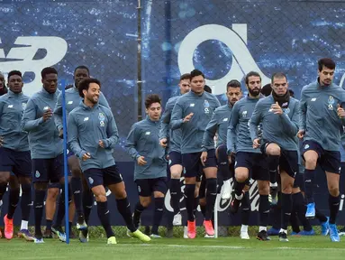 Para pemain FC Porto melakukan pemanasan saat mengikuti sesi latihan tim di tempat latihan Olival di Vila Nova de Gaia (16/2/2021). Porto akan bertanding melawan Juventus pada leg pertama babak 16 besar Liga Champions di Estadio do Dragao. (AFP/Miguel Riopa)