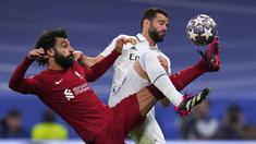 Pemain Liverpol, Mohamed Salah (kiri) berebut bola dengan pemain Real Madrid, Nacho pada laga 16 besar Liga Champions 2022/2023 yang berlangsung di Santiago Bernabeu, Madrid, Spanyol, Kamis (16/03/2023) WIB. Laga dimenangkan oleh Real Madrid dengan skor 1-0. (AP Photo/Manu Fernandez)
