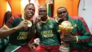 Pemain Kamerun, Clinton Njie, Vincent Aboubakar (tengah) dan Michael Ngadeu (kanan), merayakan gelar juara di ruang ganti pemain. (EPA/Gavin Barker)