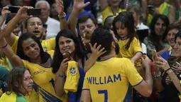 Usai berhasil menaklukkan Rusia, pevoli Brasil, William, langsung menghampiri sang putri yang berada di kursi penonton. (AFP/Juan Mabromata)