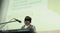 Jefri Setiawan saat menyanyikan lagu di Auditorium Kemenpora, Jakarta, Kamis (14/11). Jefri mencatat rekor dunia baru memainkan 60 lagu menggunakan keyboard dengan mata tertutup. (Liputan6.com/Helmi Fithriansyah)
