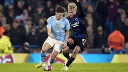 Pemain Manchester City, Julian Alvarez (kiri) berebut bola dengan pemain FC Copenhagen, Victor Froholdt pada laga leg kedua 16 besar Liga Champions 2023/2024 di Stadion Etihad, Manchester, Inggris, Kamis (07/03/2024). (AP Photo/Dave Thompson)