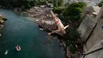Peserta melompat dari Jembatan Old Mostar pada kompetisi menyelam tradisional ke-452 di Mostar, Bosnia, 29 Juli 2018. Sebanyak 40 penyelam dari Bosnia dan negara tetangga harus melompat dari jembatan setinggi 24 meter ke Sungai Neretva. (AP/Amel Emric)