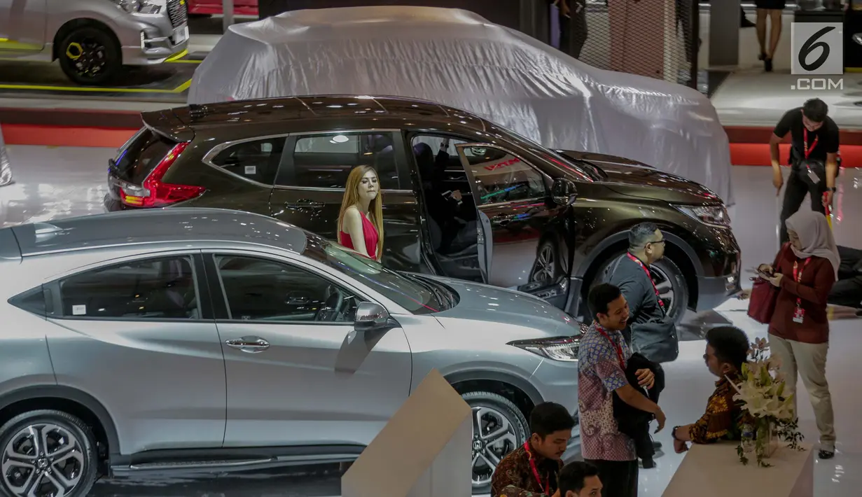 Seorang model berdiri di samping mobil yang dipamerkan saat pembukaan Indonesia International Motor Show (IIMS 2019) di JIExpo Kemayoran, Jakarta, Kamis (25/4). Pameran industri otomotif tersebut berlangsung 25 April - 5 Mei 2019. (Liputan6.com/Faizal Fanani)