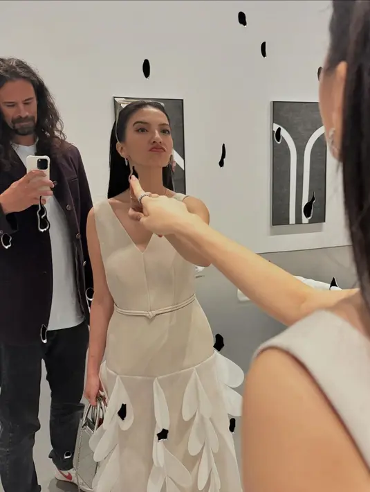 Raline Shah kembali tampil feminin dengan midi dress beige beraksen kelopak bunga di bagian rok [@ralineshah]