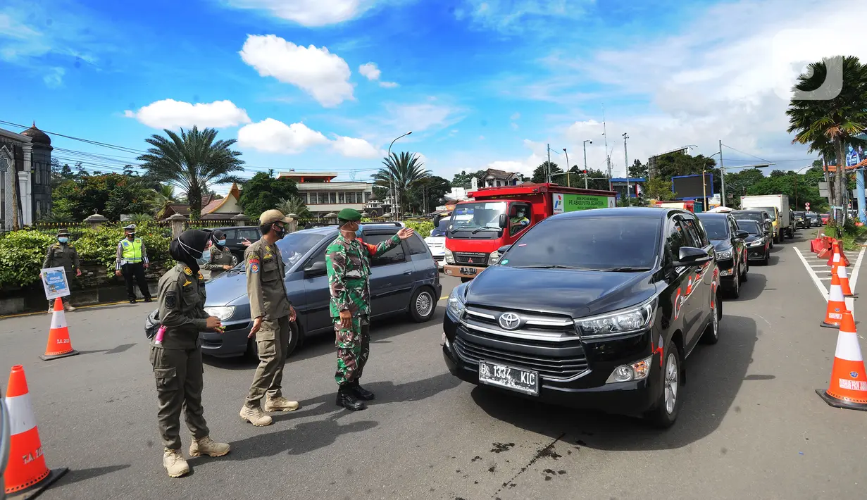 Petugas gabungan Satgas COVID-19 memeriksa kendaraan wisatawan di jalur wisata Puncak, Gadog, Bogor, Jawa Barat, Jumat (12/2/2021). Pemeriksaan dan penyekatan sebagai upaya meminimalisir penyebaran COVID-19 saat libur Tahun Baru Imlek 2572 dan akhir pekan. (merdeka.com/Arie Basuki)