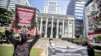 Sejumlah aktivis yang tergabung dalam #BersihkanIndonesia menggelar aksi damai di depan Gedung Mahkamah Konstitusi, Jakarta, Jumat (3/6/2022). Aksi tersebut untuk menyoroti serta menolak pengesahan revisi UU Minerba dan Omnibus Law UU Cipta Kerja. (Liputan6.com/Faizal Fanani)