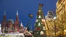 Petugas kota dengan crane mendirikan pohon Natal di Lapangan Merah, dengan Museum Sejarah, kiri, dan GUM State Department Store (kanan) di latar belakang, Moskow, Rusia, Senin (23/11/2020). Total kasus COVID-19 di Rusia saat ini telah mencapai lebih dari 2,1 juta. (AP Photo/Pavel Golovkin)