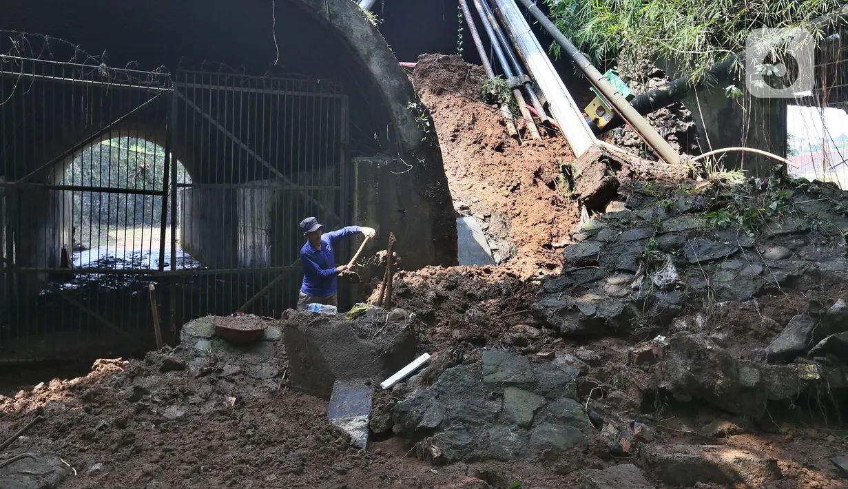 Pekerja membersihkan longsor di kawasan Jembatan Darul Qur’an, Jalan KH. Tb. M. Falak, Kecamatan Bogor Barat, Kota Bogor, Jawa Barat, Rabu (12/10/2022). Longsor yang terjadi pada kemarin sore saat hujan deras menyebabkan jalan utama yang menghubungkan Jalan Semeru dengan Jalan Raya Loji-Gunung Batu kini hanya dapat dilalui sepeda motor. (merdeka.com/Arie Basuki)