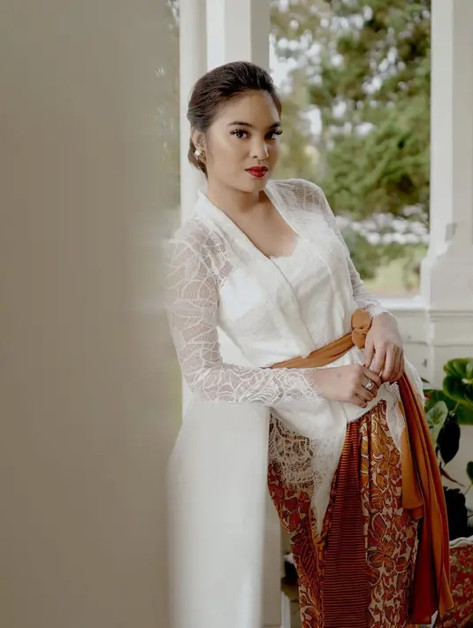 Potret lain memperlihatkan Syandria mengenakan kebaya kutubaru warna putih dengan selendang dan kain batik warna coklat. [Instagram/syandria]