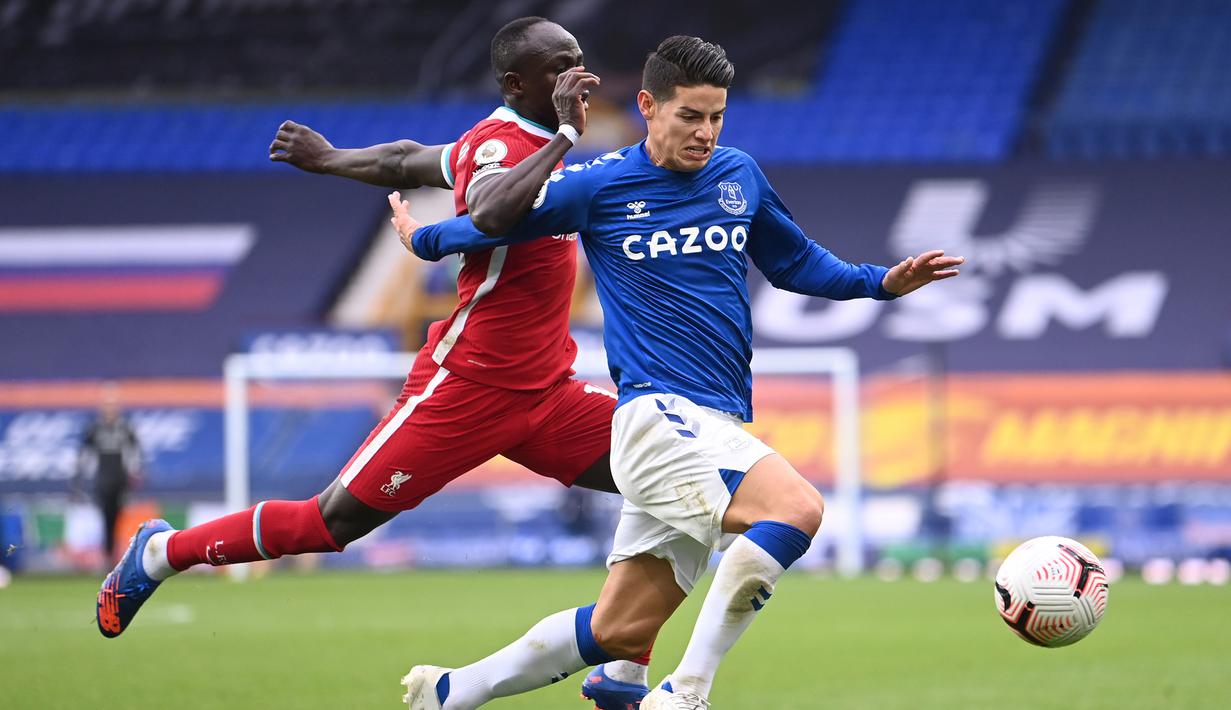 Gelandang Everton, James Rodriguez, berebut bola dengan penyerang Liverpool, Sadio Mane, pada laga lanjutan Liga Inggris di Goodison Park, Sabtu (17/10/2020) malam WIB. Liverpool bermain imbang 2-2 atas Everton. (AFP/Laurence Griffiths/pool)