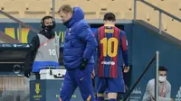 Momen di mana Lionel Messi berjalan lunglai melewati pelatih Barcelona, Ronald Koeman usai mendapat kartu merah. La Blaugrana kalah 2-3 di final Piala Super Spanyol dari Athletic Bilbao, Senin (18/01/2021) dini hari WIB. (CRISTINA QUICLER / AFP)