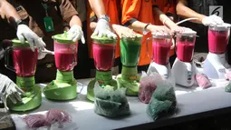 Petugas dan sejumlah tersangka memblender barang bukti 239,84 Kg sabu dan 30 ribu butir ekstasi di Polda Metro Jaya, Jakarta, Kamis (24/5). Narkoba tersebut disita dalam pengungkapan jaringan Malaysia-Jakarta. (Liputan6.com/Arya Manggala)