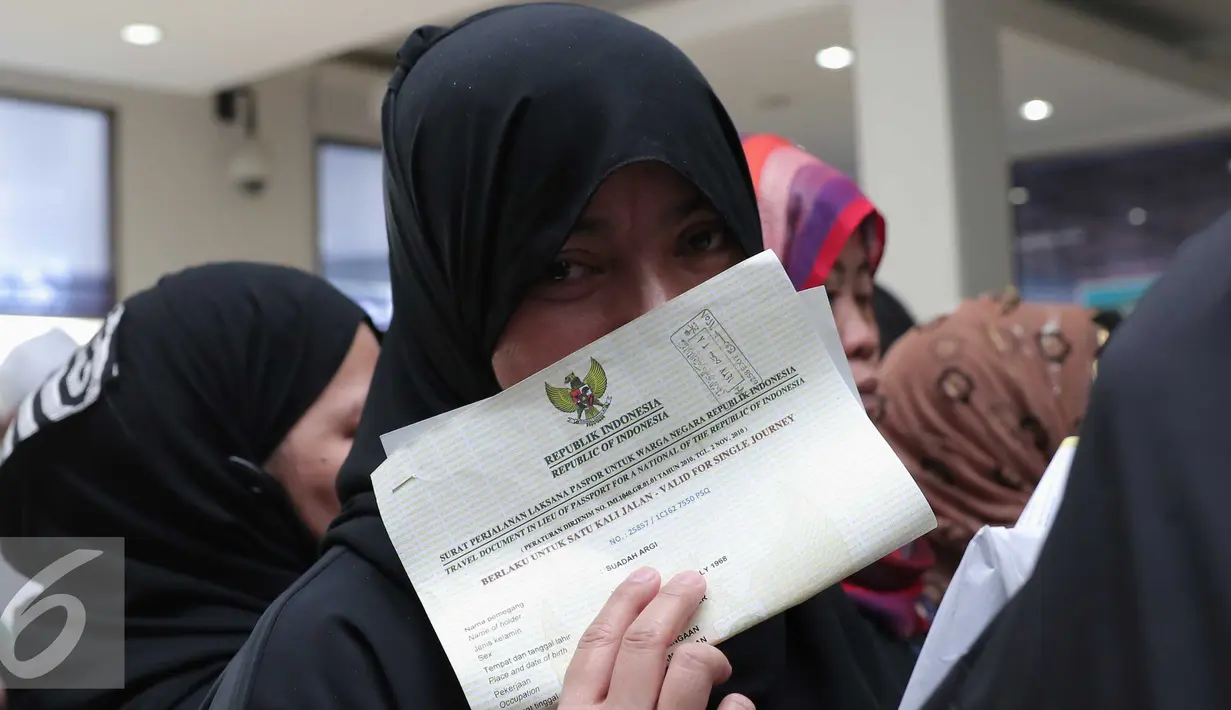 Seorang TKI memperlihatkan surat perjalanan pada wartawan di Bandara Soekarno Hatta,Tangerang, Rabu (11/11). Sebanyak 450 WNI overstayers dan TKI undocumented dari Jeddah, Arab Saudi dipulangkan pemerintah Indonesia. (Liputan6.com/Angga Yuniar)