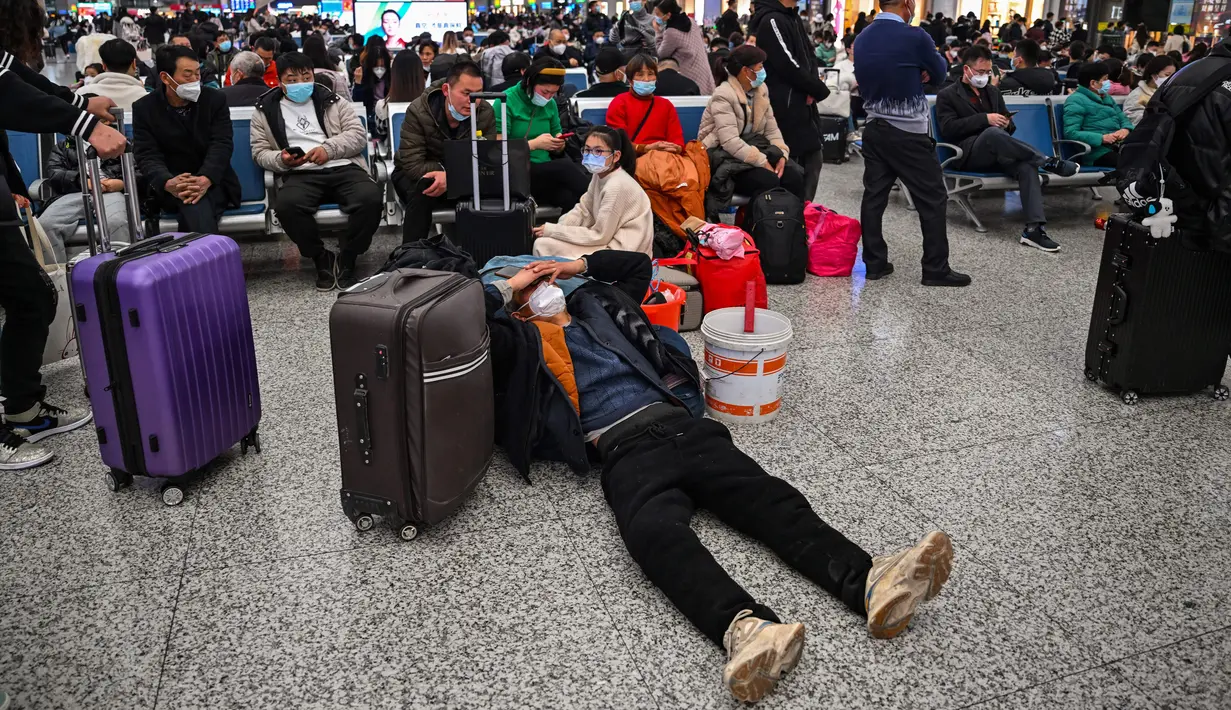 Calon penumpang menunggu kereta di Stasiun Hongqiao, Shanghai China, 11 Januari 2023. Migrasi tahunan di China dimulai dengan orang-orang kembali ke kampung halaman mereka untuk merayakan Tahun Baru Imlek. (Hector RETAMAL/AFP)