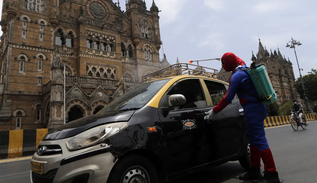 Pekerja sosial India Ashok Kurmi berpakaian seperti Spider Man mendesinfeksi taksi di dekat stasiun kereta Chhatrapati Shivaji Maharaj selama lockdown yang diberlakukan di Mumbai, Rabu (21/4/2021). Kegiatan tersebut dilakukan untuk mengekang penyebaran COVID-19 di Mumbai. (AP Photo/Rajanish Kakade)