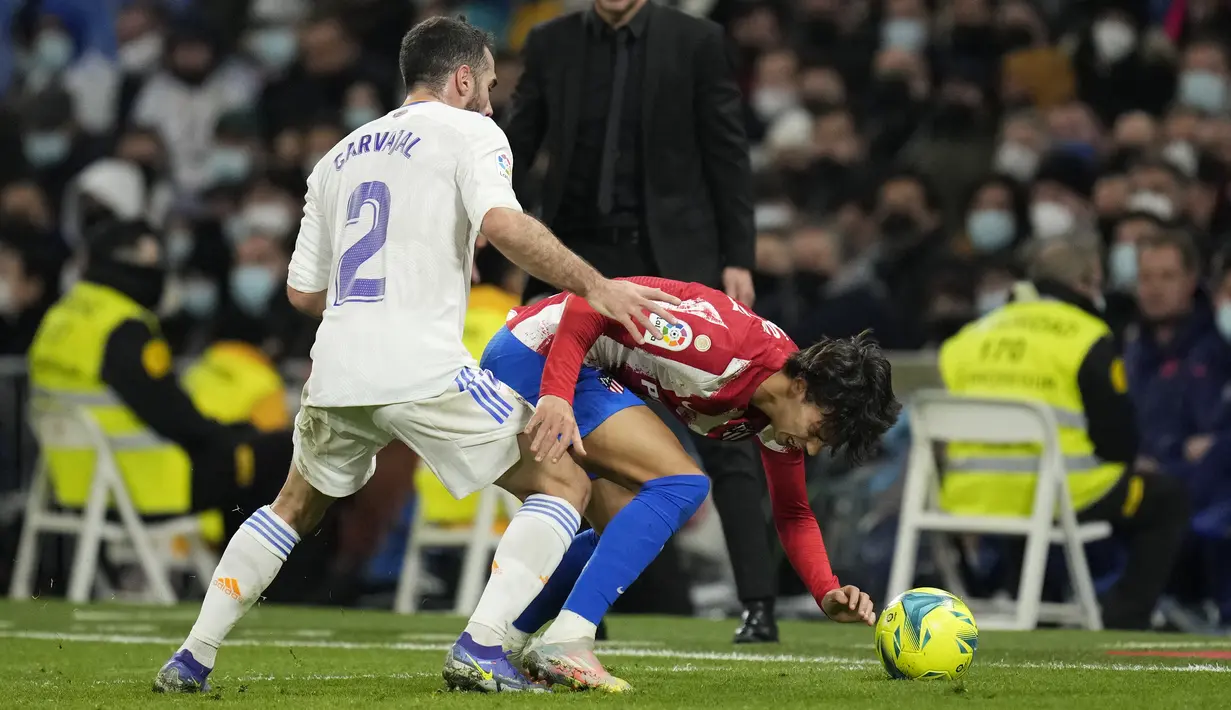 Bek Real Madrid Dani Carvajal berebut bola dengan penyerang Atletico Madrid Joao Felix pada pekan ke-17 Liga Spanyol di Santiago Bernabeu, Senin dini hari WIB (13/12/2021). Real Madrid berhasil menaklukkan rival sekotanya Atletico Madrid dengan skor 2-0. (AP Photo/Bernat Armangue)