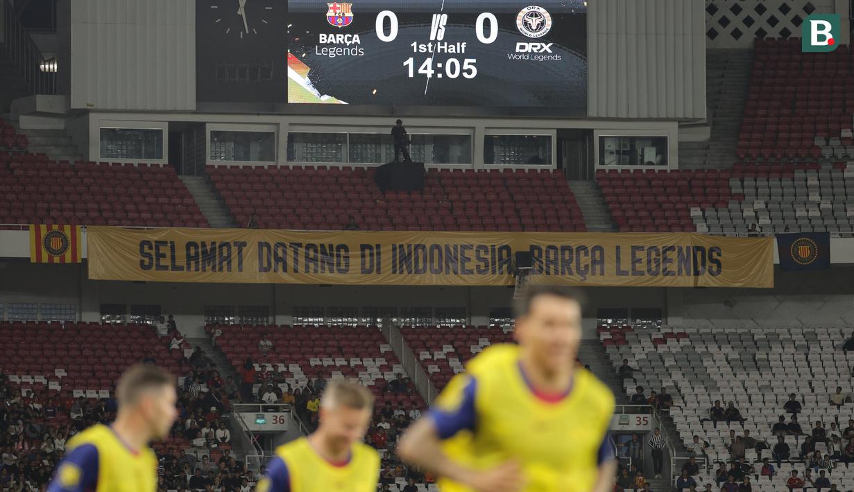 Suporter Indonesia membentangkan banner bertulis "selamat datang di Indonesia Barca Legends" dalam laga Clash of Legends antara Barcelona Legends melawan DRX World Legends di Stadion Utama Gelora Bung Karno (SUGBK), Senayan, Jakarta, Sabtu (18/04/2026). (Bola.com/Bagaskara Lazuardi)