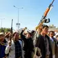 Militan Houthi mengacungkan senjata saat unjuk rasa solidaritas terhadap warga Palestina di Sana'a, ibu kota Yaman yang dikuasai Huothi. (AFP/Mohammed Huwais)